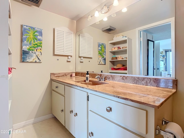 bathroom featuring visible vents, baseboards, and vanity