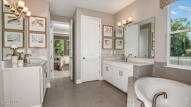 bathroom featuring tiled tub, vanity, and tile patterned floors