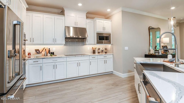 kitchen with light hardwood / wood-style flooring, stainless steel appliances, tasteful backsplash, light stone counters, and white cabinets