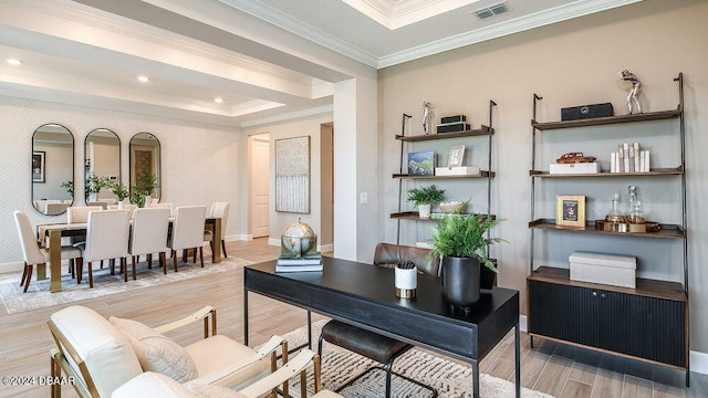 home office featuring a tray ceiling, ornamental molding, and light hardwood / wood-style floors