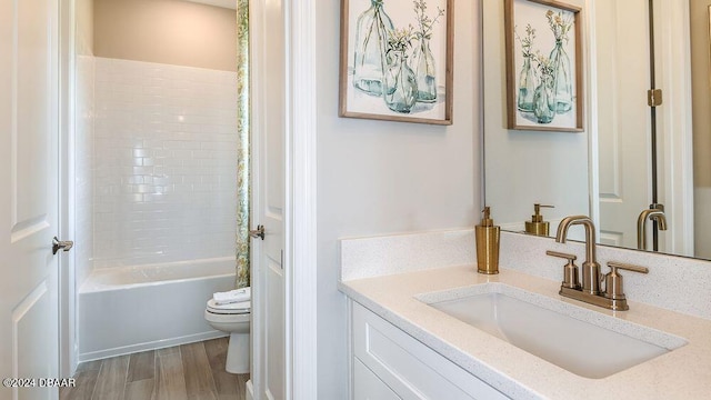 full bathroom featuring vanity, hardwood / wood-style floors, tub / shower combination, and toilet