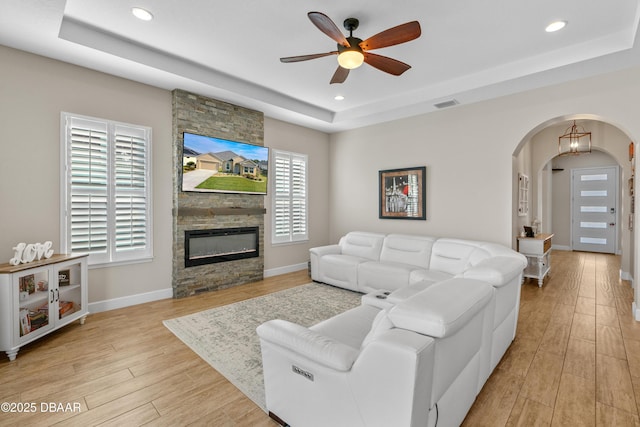 6871 Forkmead Ln, Port Orange, FL 32128 - living area featuring a tray ceiling, arched walkways, light wood-style floors, recessed lighting, and a ceiling fan