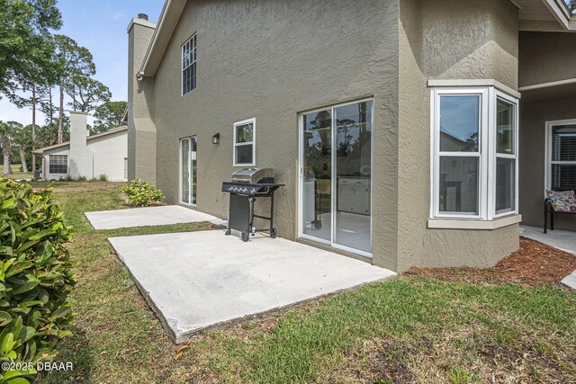 108 Shoal Creek Cir, Daytona Beach, FL 32114 - rear view of house featuring a patio, a yard, stucco siding, and a chimney