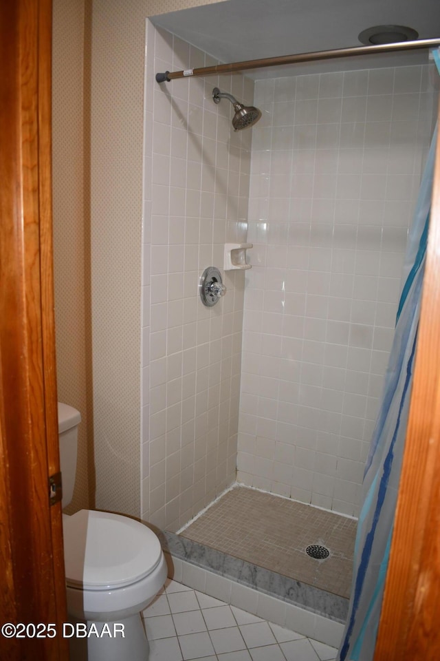 full bath featuring tile patterned floors, toilet, and a stall shower