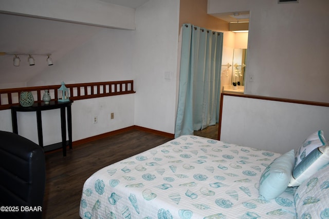 bedroom featuring visible vents, rail lighting, baseboards, and wood finished floors