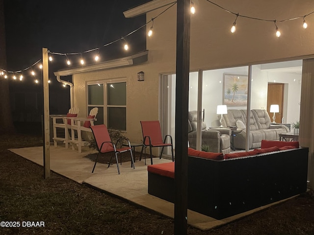 patio at night featuring an outdoor living space