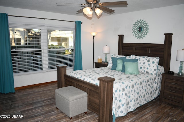 bedroom featuring baseboards, dark wood finished floors, and a ceiling fan