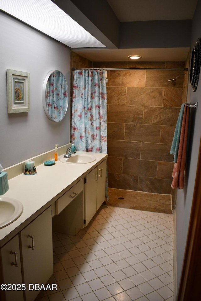 bathroom with double vanity, a tile shower, and a sink