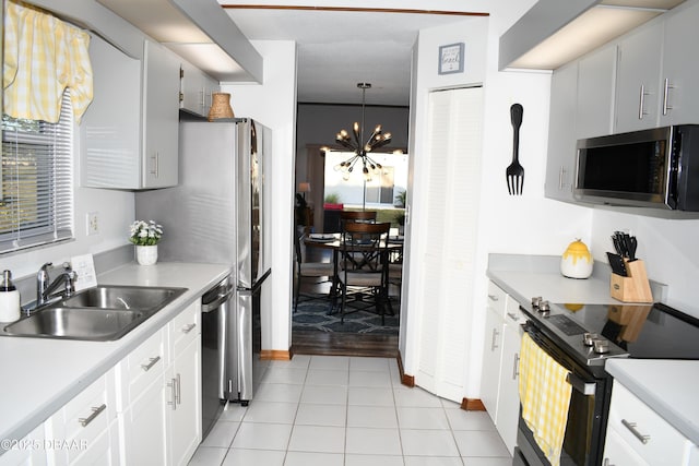 kitchen with a sink, stainless steel appliances, light countertops, and light tile patterned floors