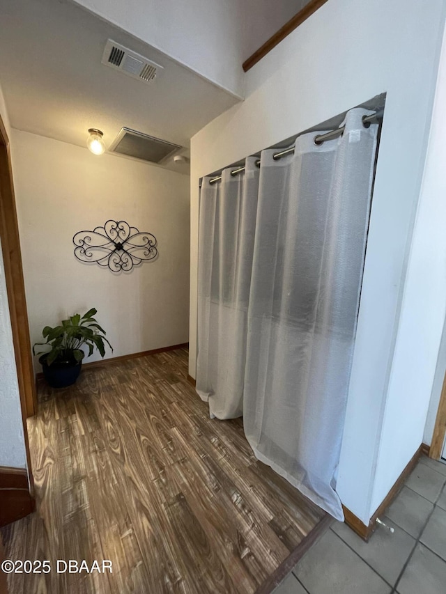 bathroom featuring wood finished floors, visible vents, and baseboards