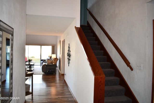 staircase with visible vents and wood finished floors