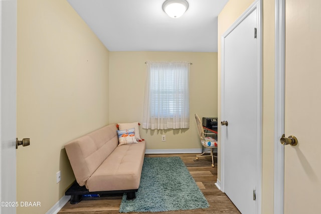 sitting room with baseboards and wood finished floors