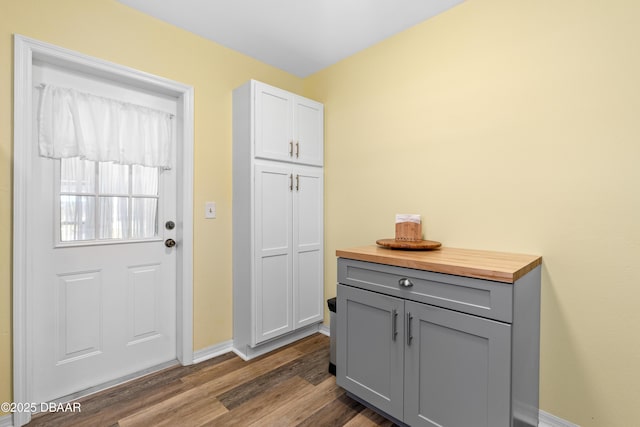 entryway with dark wood-style floors and baseboards