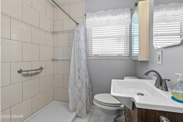 bathroom with tile patterned floors, toilet, vanity, and a tile shower