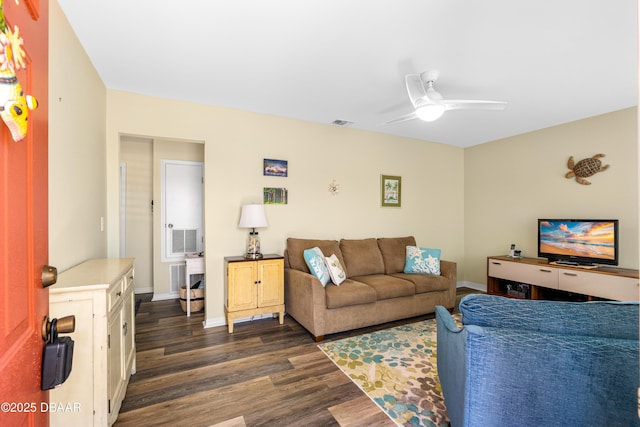 living room with dark wood-type flooring, baseboards, visible vents, and ceiling fan