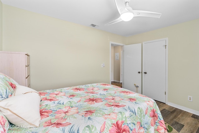 bedroom featuring a ceiling fan, wood finished floors, visible vents, and baseboards