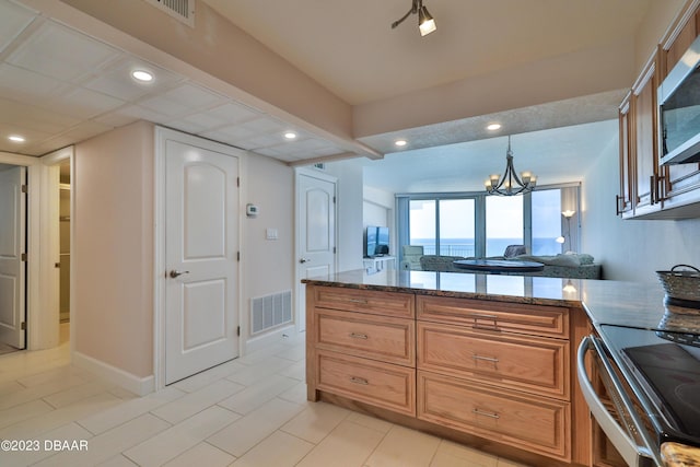 kitchen with stainless steel appliances, decorative light fixtures, a chandelier, and stone countertops