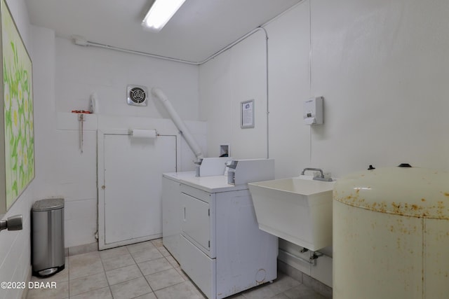 laundry area featuring separate washer and dryer, sink, and light tile patterned floors