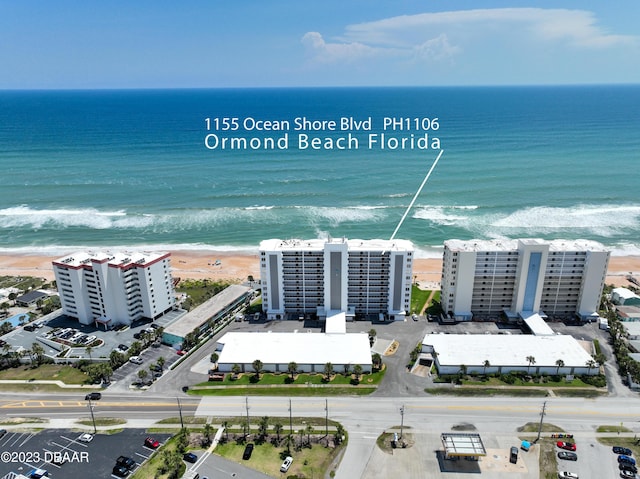 drone / aerial view featuring a water view and a beach view