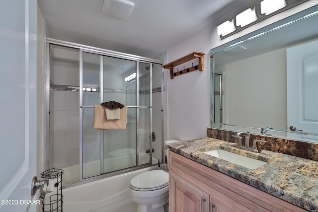 full bathroom featuring toilet, vanity, and shower / bath combination with glass door