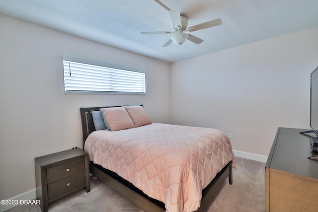 carpeted bedroom with ceiling fan and a textured ceiling