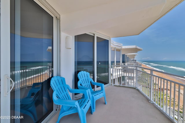 balcony featuring a water view and a view of the beach