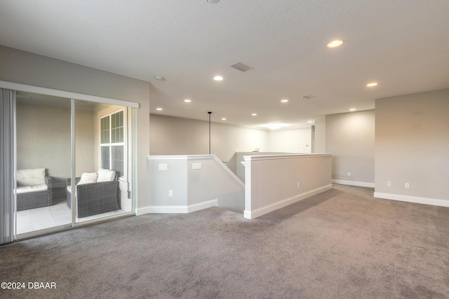 unfurnished room with carpet flooring and a textured ceiling