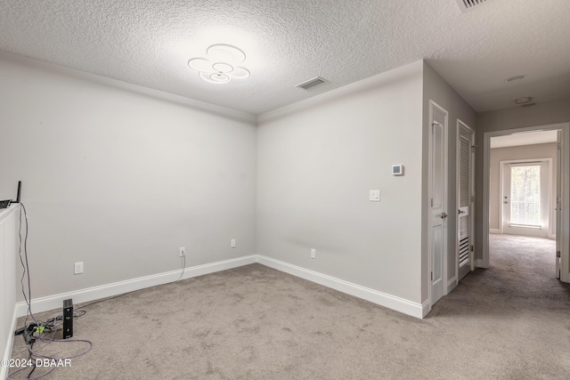 spare room with carpet flooring and a textured ceiling