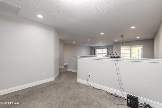 carpeted spare room featuring a textured ceiling