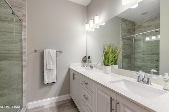 bathroom with hardwood / wood-style floors, vanity, and a shower with shower door