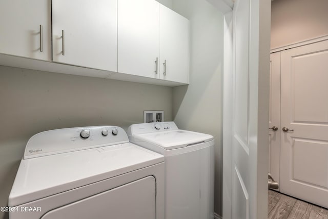 laundry area featuring light hardwood / wood-style floors, cabinets, and independent washer and dryer