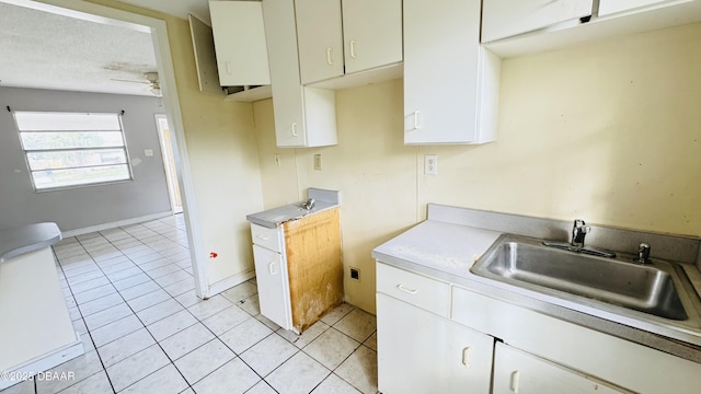 kitchen with white cabinetry, sink, ceiling fan, and light tile patterned flooring