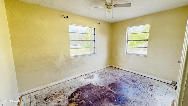 empty room featuring a textured ceiling and ceiling fan