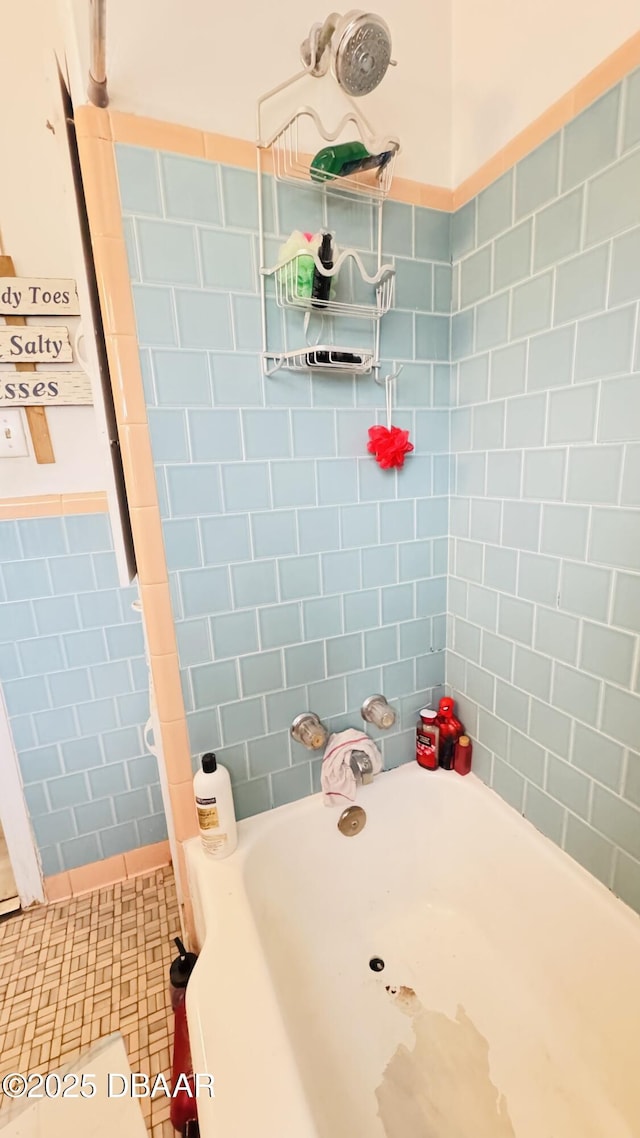 bathroom featuring tiled shower / bath combo and tile walls