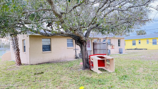 back of house featuring cooling unit and a yard