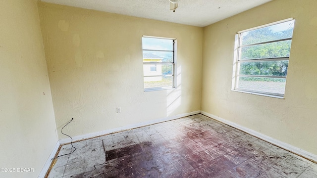 empty room with plenty of natural light and a textured ceiling