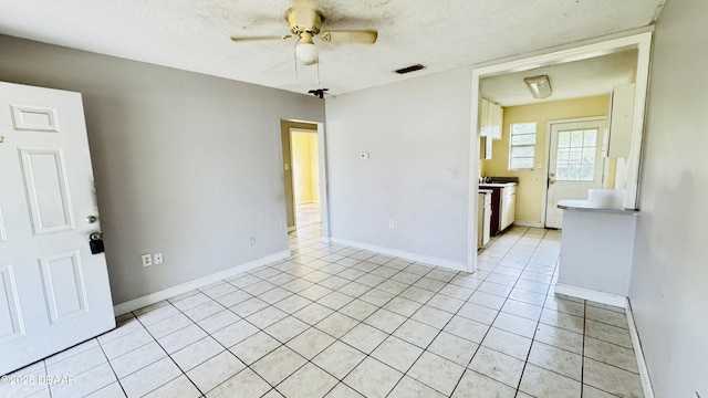 tiled spare room featuring a textured ceiling and ceiling fan