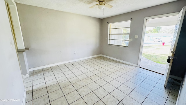 unfurnished room with ceiling fan and a textured ceiling