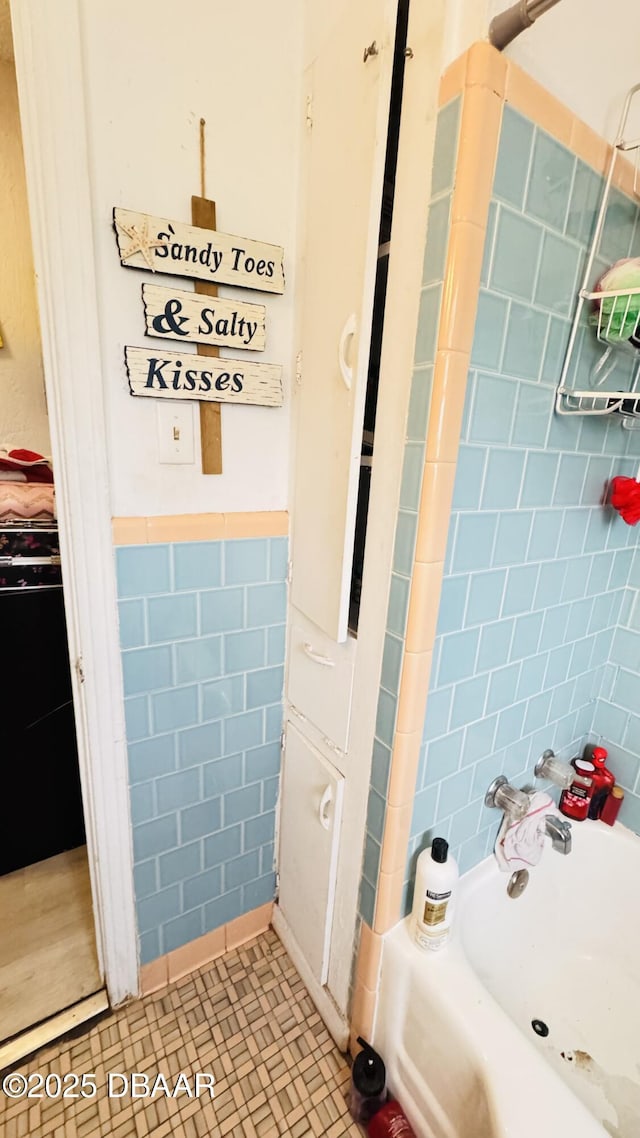 bathroom featuring tile patterned flooring and tile walls