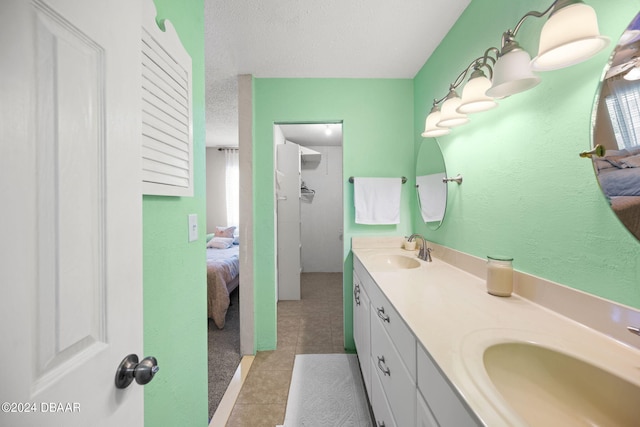 bathroom featuring vanity, tile patterned floors, and a textured ceiling