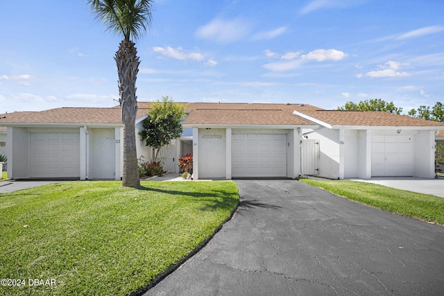 ranch-style home with a garage, stucco siding, and a front lawn