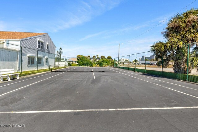 uncovered parking lot with fence and a tennis court