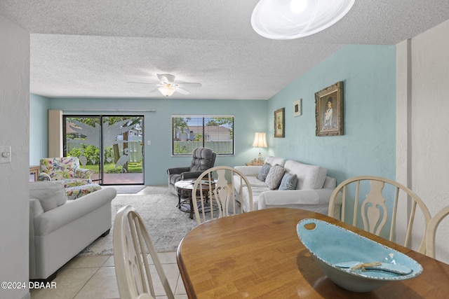 tiled dining area with ceiling fan and a textured ceiling