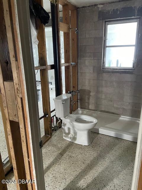 bathroom featuring a shower and toilet