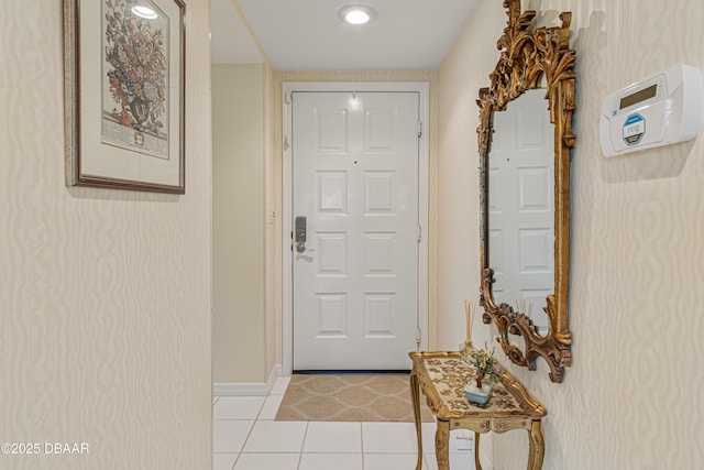 doorway featuring light tile patterned floors and baseboards
