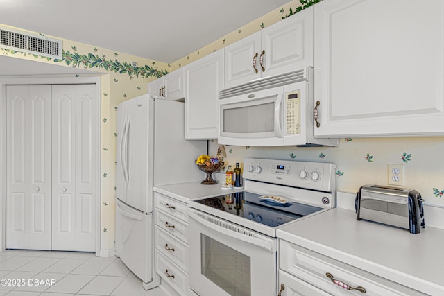 kitchen featuring white appliances, light tile patterned flooring, white cabinets, and visible vents
