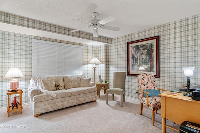 carpeted living room with a ceiling fan, wallpapered walls, and a textured ceiling