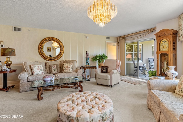 carpeted living area with a textured ceiling, an inviting chandelier, and visible vents