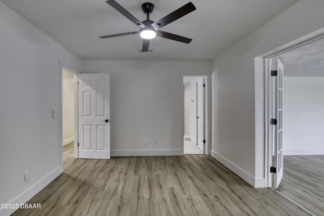 1704 Travelers Palm Dr, Edgewater, FL 32132 - unfurnished bedroom with wood finished floors, baseboards, a spacious closet, and a ceiling fan