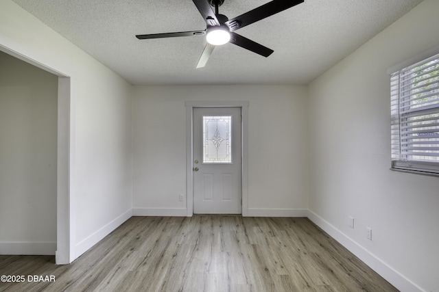 1704 Travelers Palm Dr, Edgewater, FL 32132 - spare room featuring light wood-style flooring, ceiling fan, a textured ceiling, and baseboards